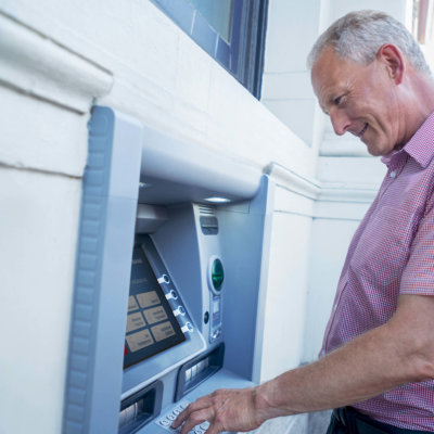 Older Man In Front ATM Machine Bank Entering Pin Code